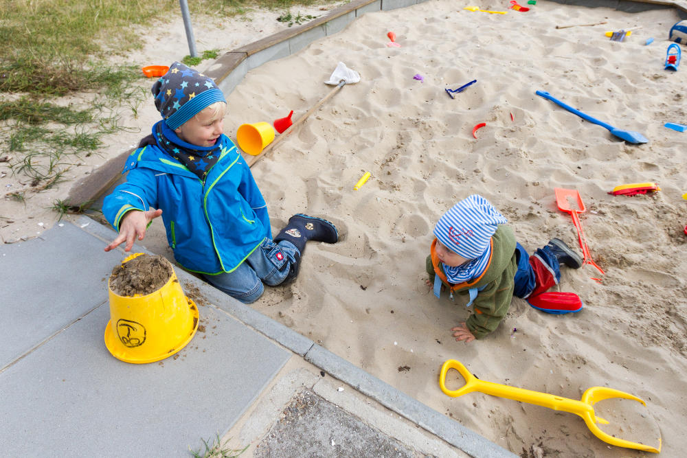 Zwei Kinder spielen im Sandkasten des CVJM Hauses Quellerdünen